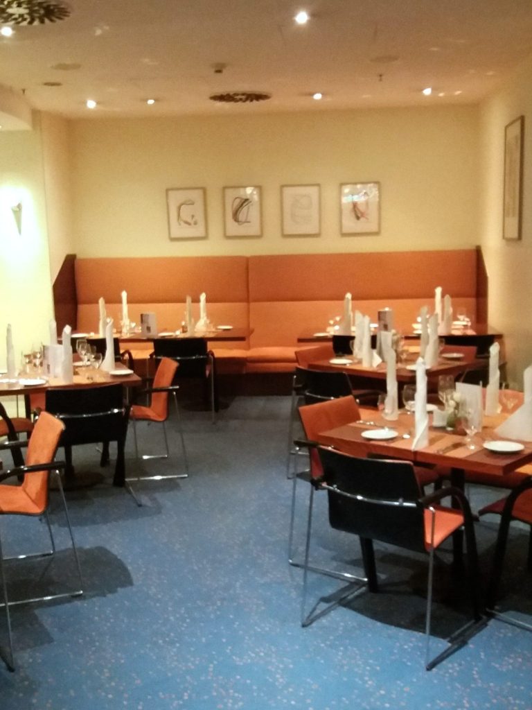 Feng Shui im Restaurant Elegantes Restaurant mit Tischen, Stühlen und dekorativen Bildern an den Wänden.